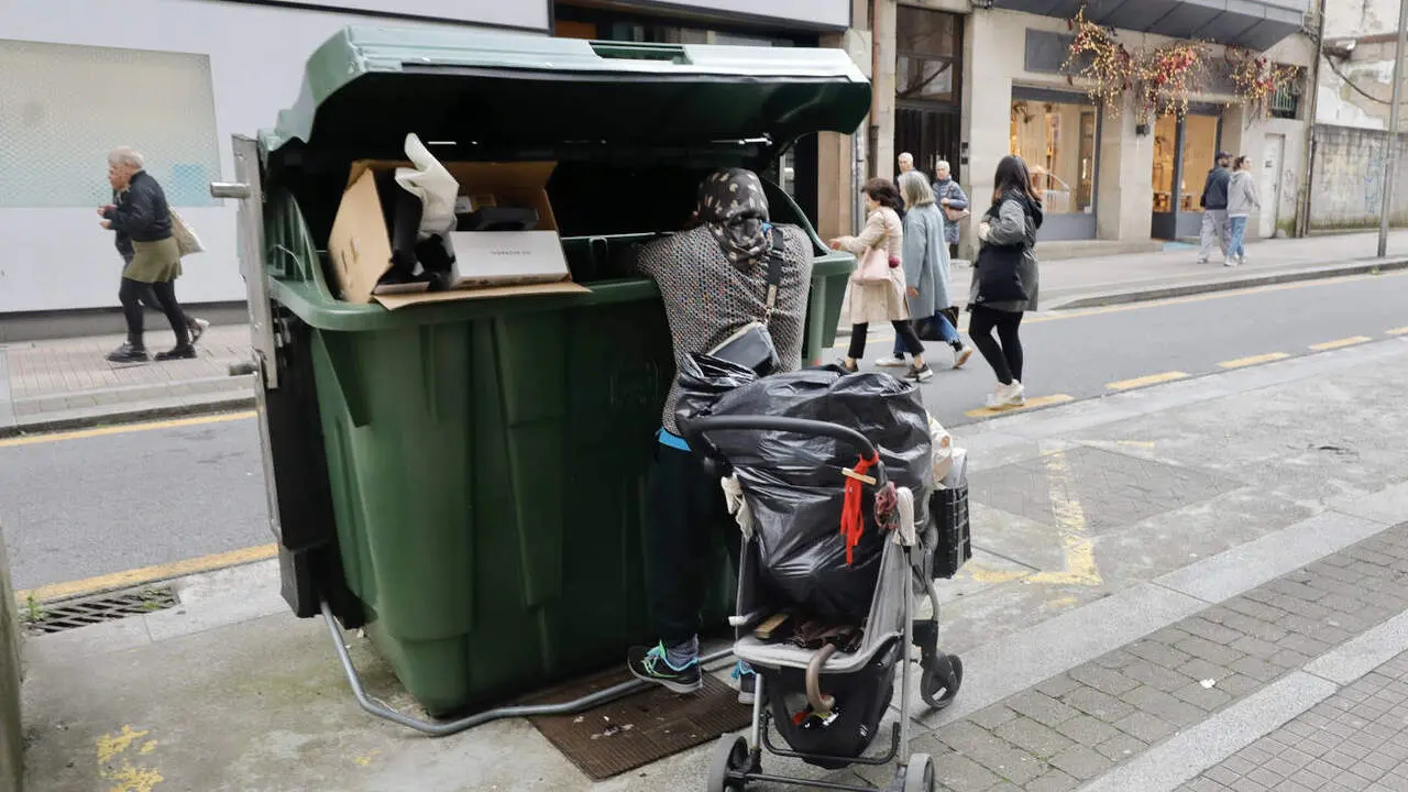 Una mujer rebuscando en un contenedor de basura en Pontevedra. DAVID FREIRE