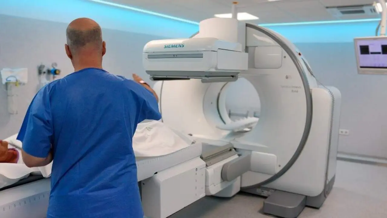 Un sanitario prepara a un paciente para un TAC. EFE