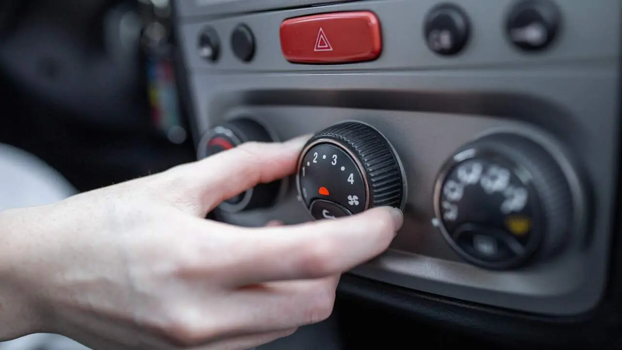 Una persona regula la calefacción en su coche. FREEPIK