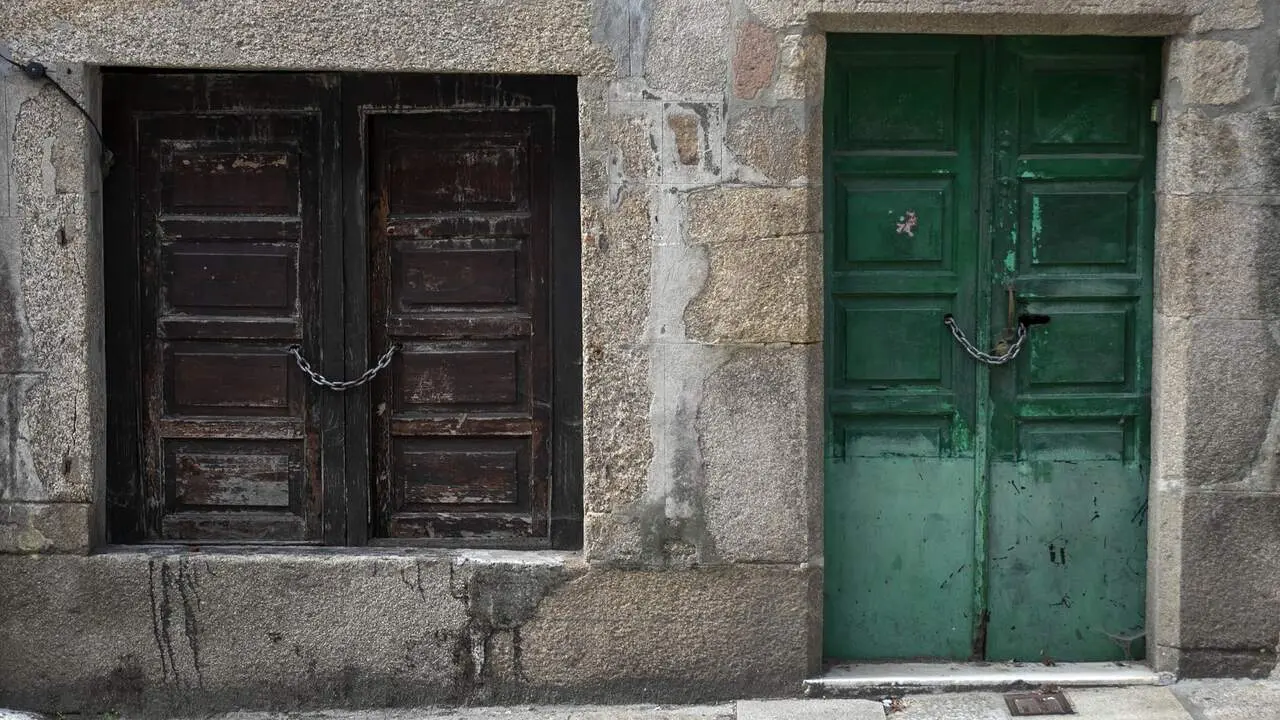 Dos puertas cerradas y encadenadas en una vivienda tradicional gallega. XUNTA