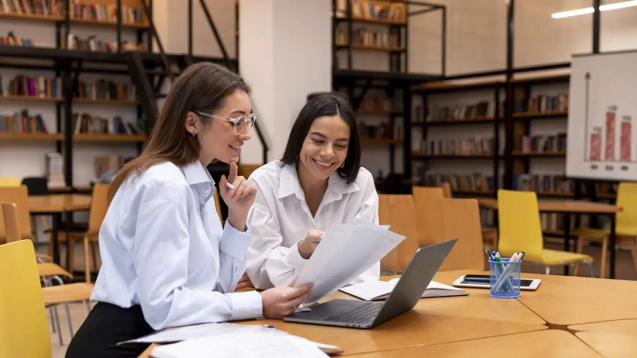 Estudiantes trabajando en una biblioteca. FREEPIK