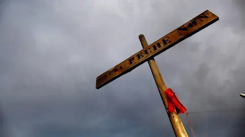 Una cruz con el lema 'Alcoa, peche non', a la entrada de la planta de A Coru&ntilde;a. CABALAR (EFE)