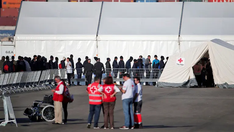 Imagen de los primeros inmigrantes atendidos en el puerto valenciano. MANUEL BRUQUE (EFE)