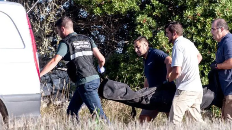 Agentes de la Guardia Civil y de los servicios funerarios trasladan los restos mortales de una mujer, posiblemente miembro del matrimonio alem&aacute;n que se daba por desaparecido, hallado en el municipio de Art&agrave;. CATI CLADERA (Efe)