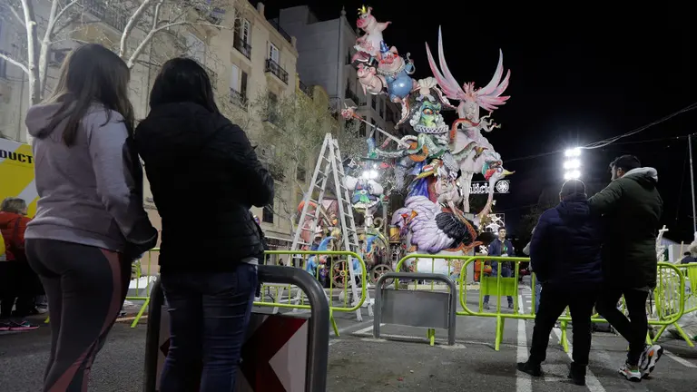 Unos jóvenes observan una falla a medio montar en Valencia. EFE