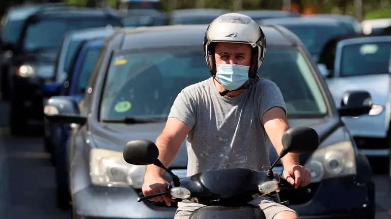 Un motorista circula con la mascarilla puesta por el centro de Madrid. MARISCAL (EFE)