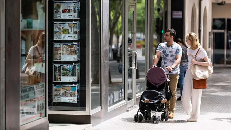 Una pareja pasa ante una inmobiliaria. EUROPA PRESS