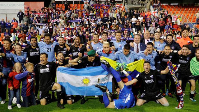 Jugadores y aficionados del Huesca celebran el ascenso en el Ángel Carro. ELISEO TRIGO (EFE)