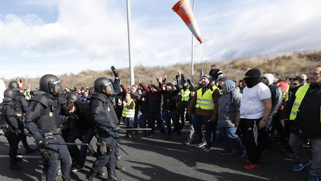 Tensión entre taxistas y antidisturbios ante una de las entradas de Fitur. JAVIER LIZÓN (EFE)