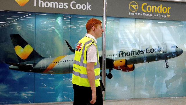 Un operario camina frente al puesto de información de la operadora de viajes Thomas Cook en Mallorca. CATI CLADERA