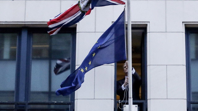 Un funcionario retira la bandera de la UE. EFE