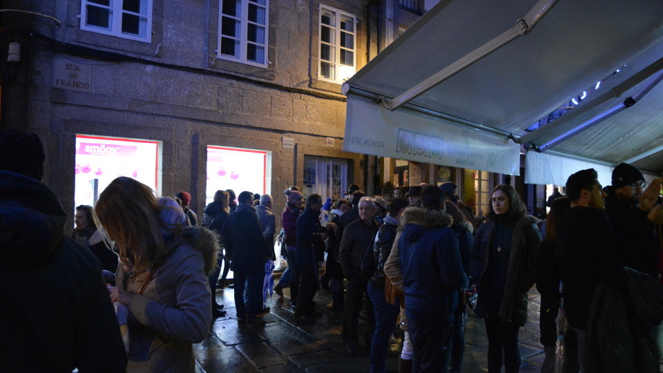 Vistantes e habitantes de Compostela facendo cola na coñecida Administración nº3 de Lotería para mercar o seu décimo de Nadal. ÁNGEL CARRO