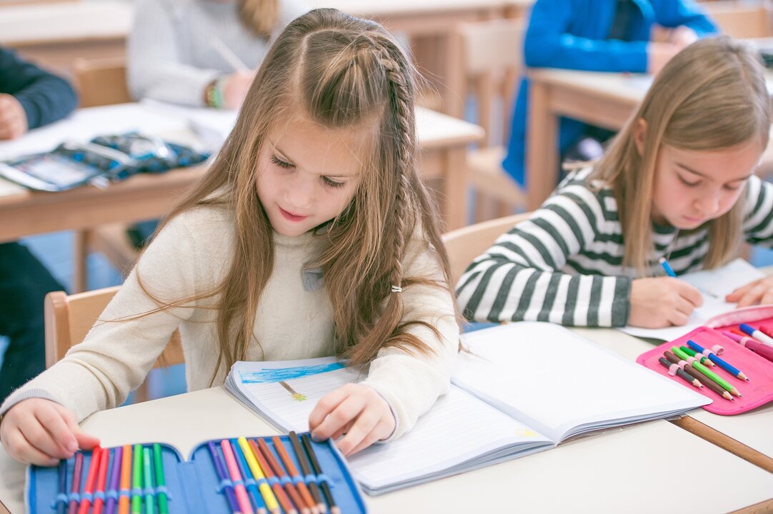 Niñas con su material escolar en un centro educativo. EUROPA PRESS